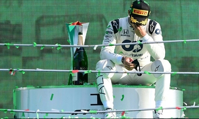 Gasly ôm mặt trên bục nhận thưởng, sau khi nhận Cup chiến thắng và champagne. Ảnh: AFP.