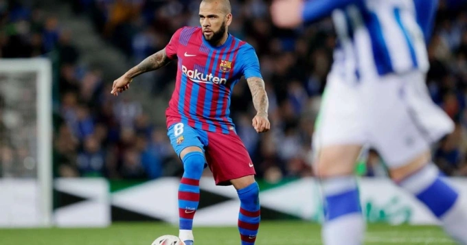Alves (trái) thi đấu trong trận thắng Sociedad tối 21/4. Ảnh: Reuters.