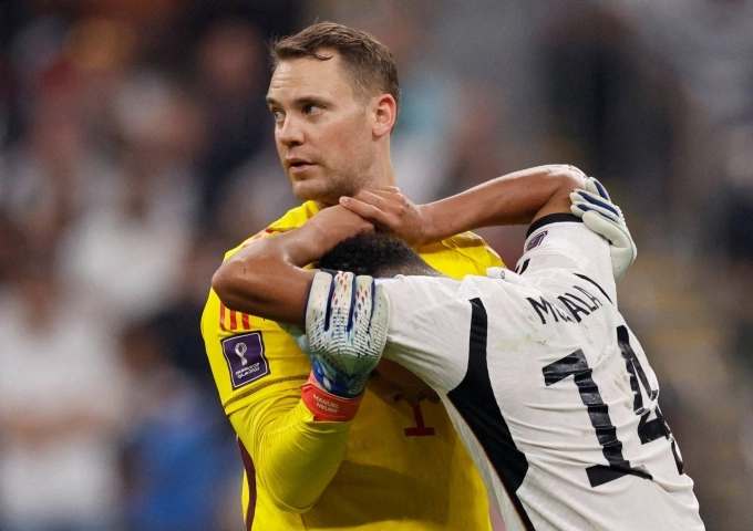 Neuer an ủi Musiala sau khi Đức biết tin bị loại ở vòng bảng World Cup 2022. Thủ môn 36 tuổi được dự báo sẽ phải rời tuyển Đức, để trao lại vị thế đầu đàn cho thế hệ trẻ hơn. Ảnh: Reuters