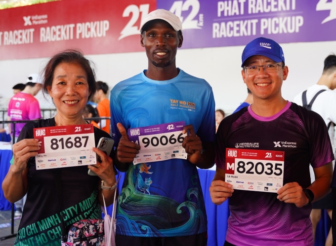 Anh Lê Hoàn (phải), Kiptoo (giữa) và bà Yến nhận Bib VM Huế 2024, sáng 20/4. Ảnh: Tiến Nguyễn