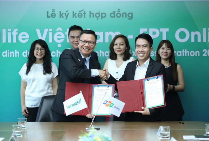 Ông Vũ Văn Thắng (trái) - Tổng giám đốc Herbalife Việt Nam và Campuchia cùng ông Ngô Mạnh Cường - Tổng giám đốc FPT Online trao biên bản ghi nhớ hợp tác. Ảnh: Phạm Chiểu