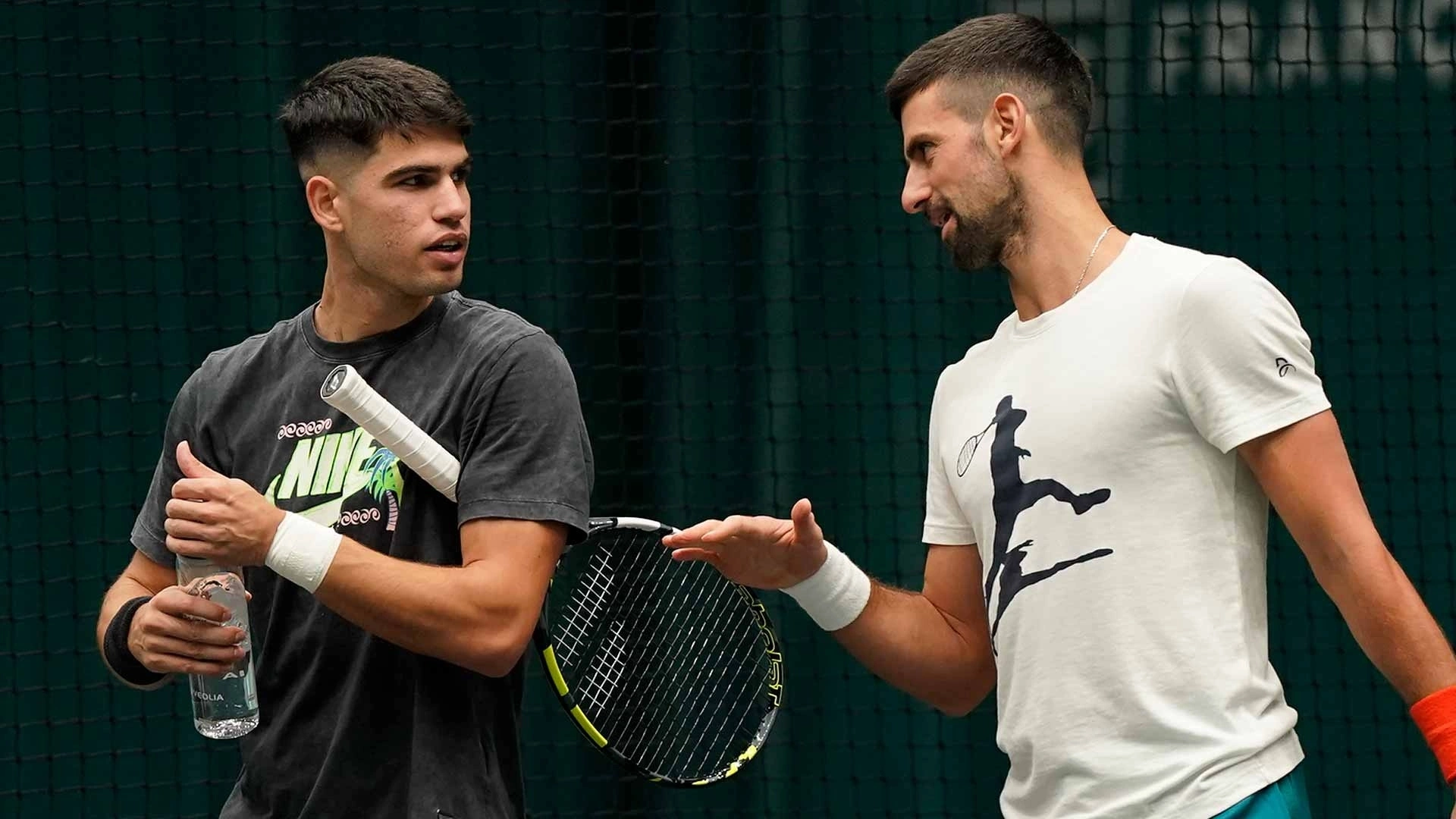 Djokovic (phải) trao đổi với Alcaraz trong một buổi tập năm 2023. Ảnh: Reuters