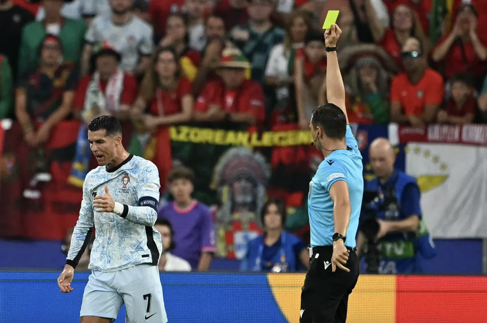Cristiano Ronaldo (trái) nhận thẻ vàng từ trọng tài Sandro Scharer vì phản ứng quá mức khi đòi phạt đền, trong trận Bồ Đào Nha thua Gruzia 0-2, tại lượt cuối bảng F Euro 2024. Ảnh: AFP