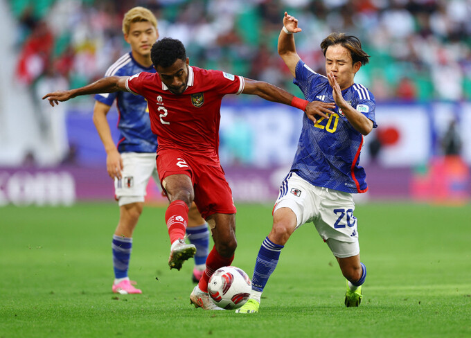 Yakob Sayuri (áo đỏ) tranh chấp với Takefusa Kubo ở trận Nhật Bản thắng Indonesia 3-1, tại vòng bảng Asian Cup 2023. Ảnh: Reuters