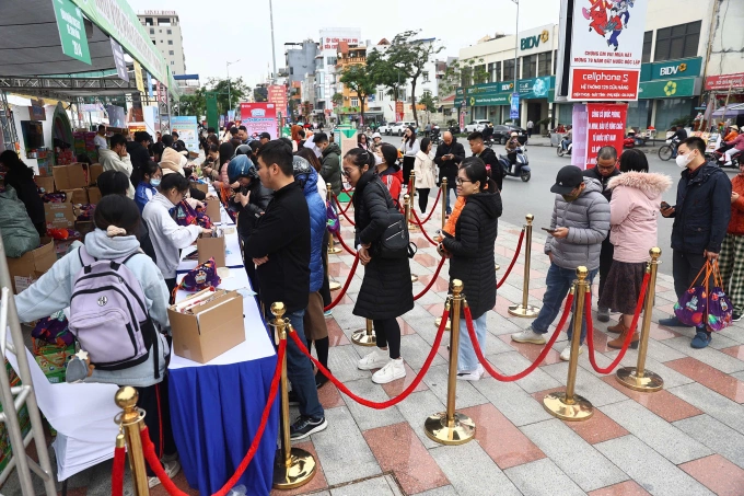 Phụ huynh xếp hàng dài, mặc áo ấm, chờ nhận bib Kun. Ảnh: Quỳnh Trần