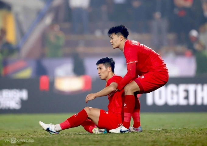 Nguyễn Thành Chung (phải) nâng Bùi Tiến Dũng đứng dậy sau khi cả hai không thể ngăn cản Chalermsak Aukkee đánh đầu rút ngắn tỷ số xuống 1-2 cho Thái Lan. Ảnh: Đức Đồng