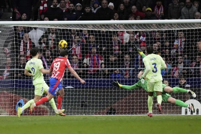 Alvarez (áo sọc đỏ trắng) mở tỷ số trận Atletico 2-4 Barca ở vòng 28 La Liga tối 16/3. Ảnh: AP