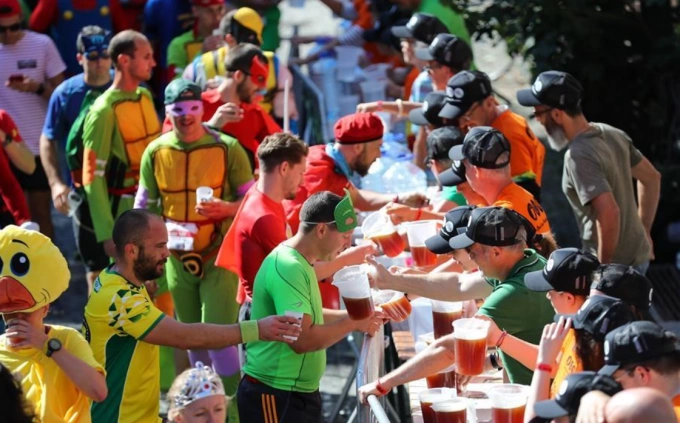 Các runner lấy bia khi dự Beer Lovers Marathon. Ảnh: News.cn