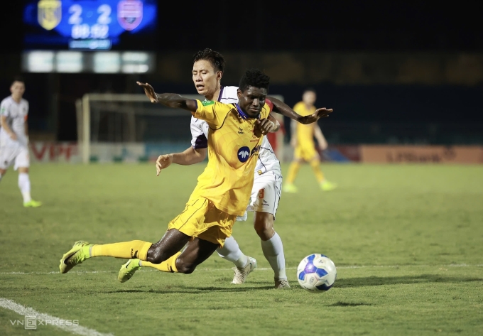 Quế Ngọc Hải (áo trắng) phạm lỗi với Michael Olaha dẫn đến phạt đền giúp SLNA thắng Bình Dương 3-2 ở bán kết Cup Quốc gia 2024-2025, trên sân Vinh, Nghệ An ngày 26/6/2025. Ảnh: Xuân Thủy