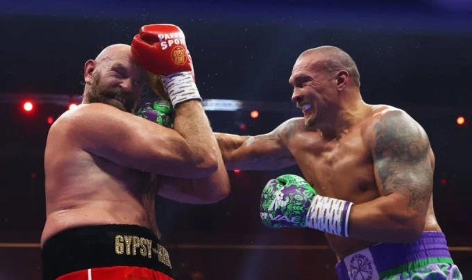 Usyk (phải) ra đòn trúng mặt Tyson Fury trong trận tranh ba đai hạng nặng tại Kingdom Arena, Riyadh, Arab Saudi tối 21/12/2024. Ảnh: AP
