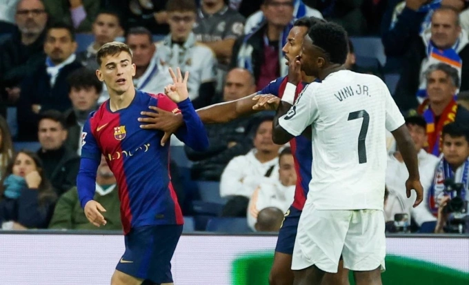 Gavi (trái) đối đáp với Vinicius trong trận Real 0-4 Barca ở La Liga mùa trước. Ảnh: EFE