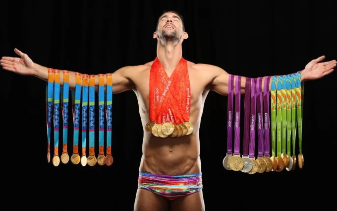 Michael Phelps tạo dáng với tất cả huy chương Olympic. Ảnh: Sports Illustrated