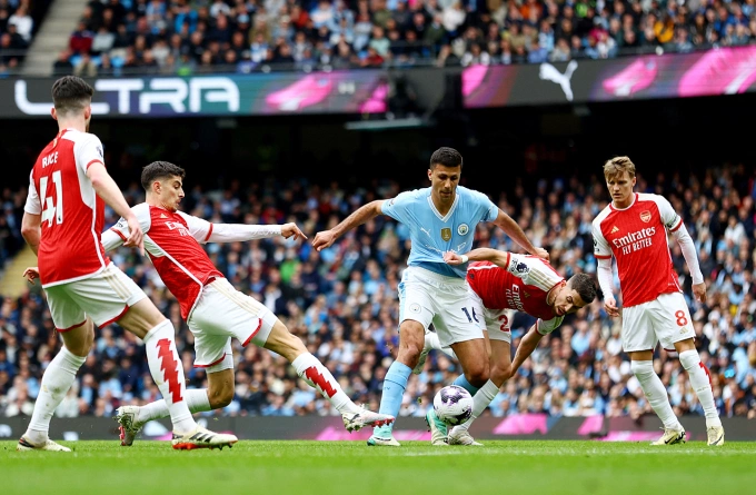 Rodri của Man City (áo xanh) cầm bóng giữa vòng vây cầu thủ Arsenal, trong trận đấu ở Ngoại hạng Anh trên sân Etihad, thành phố Manchester, Anh ngày 31/3/2024. Ảnh: Reuters