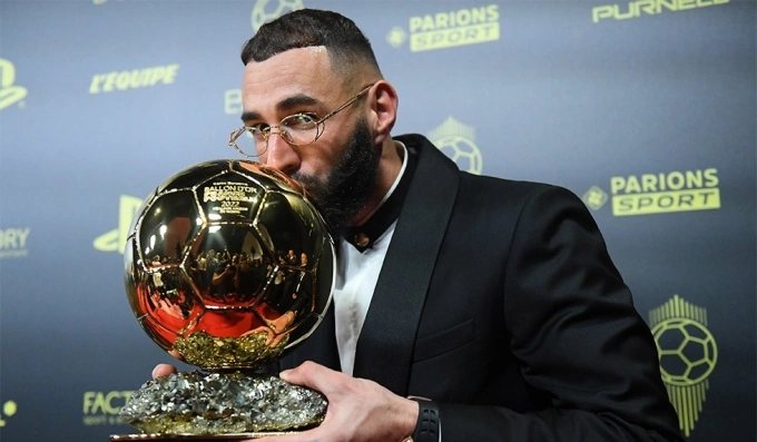 Benzema hôn lên Quả Bóng Vàng 2022. Ảnh: France Football