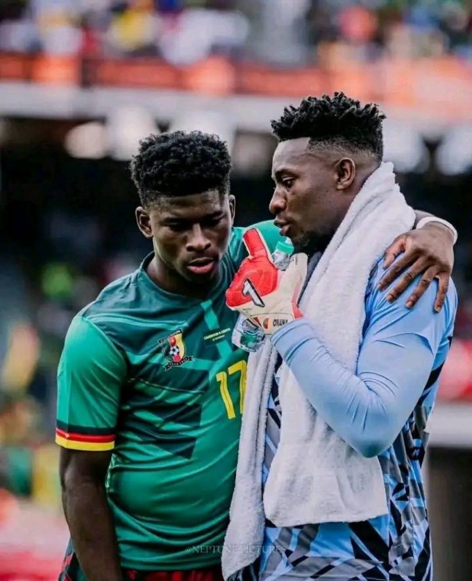Andre Onana (phải) trò chuyện với Carlos Baleba trên tuyển Cameroon.