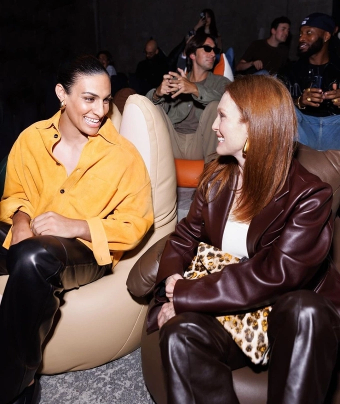 Khelif (áo vàng) ngồi cạnh minh tinh Hollywood Juliane Moore tại Tuần lễ Thời trang Milan 2024. Ảnh: AFP