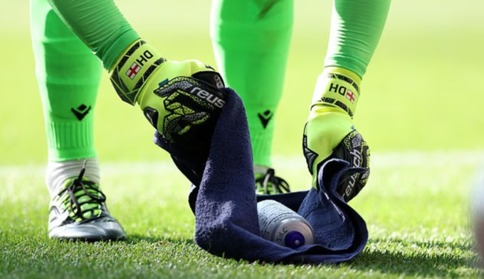 Dean Henderson xem chỉ dẫn trên chai nước trước từng lượt sút của Liverpool. Ảnh: Sportimage