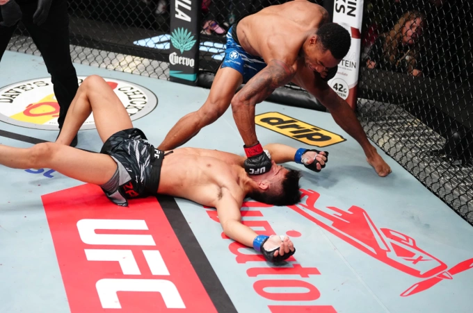 Elijah Smith ra đòn khi Toshiomi Kazama nằm sàn bất tỉnh ở trận đấu hạng gà UFC Vegas 109 tại Las Vegas, Mỹ ngày 9/8. Ảnh: UFC