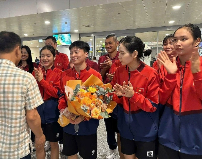 Đội trưởng Đặng Thị Hồng nhận hoa chức mừng khi về sân bay Nội Bài, chiều 18/8. Ảnh: Thanh Nhàn