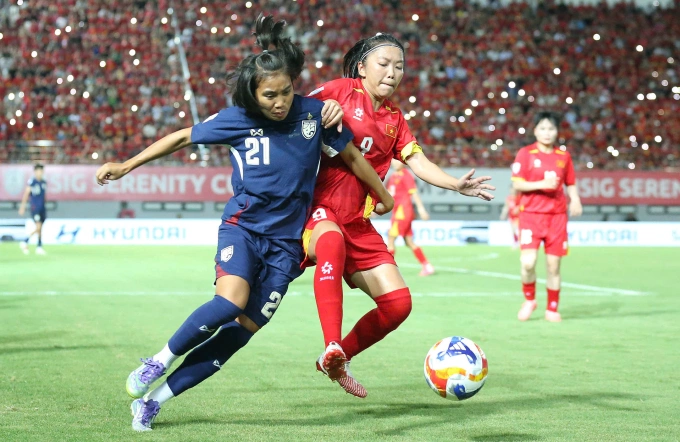 Tiền đạo Huỳnh Như tranh bóng cùng cầu thủ Thái Lan ở trận đấu vòng bảng ASEAN Cup nữ 2025 trên sân Lạch Tray, Hải Phòng ngày 12/8. Ảnh: Lê Tân