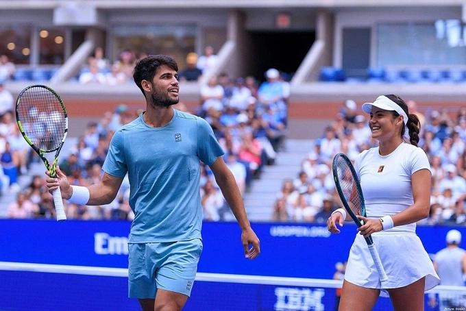 Alcaraz (trái) và Raducanu trong trận vòng đầu đôi nam nữ Mỹ Mở rộng, trên sân Arthur Ashe, New York hôm 20/8. Ảnh: Reuters