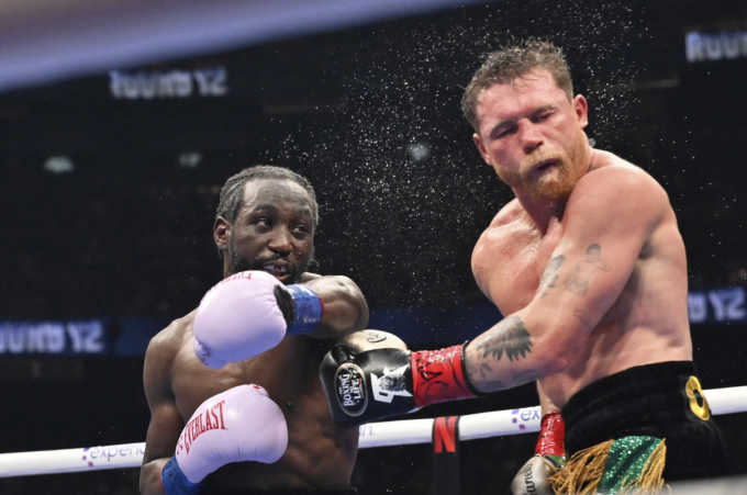 Terence Crawford (trái) tung đòn trúng mặt Canelo Alvarez trong trận thống nhất các đai hạng siêu trung trên sân Allegiant, Las Vegas, Mỹ ngày 13/9/2025. Ảnh: AP