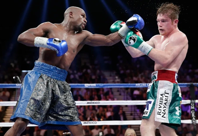 Canelo Alvarez (phải) nhận đòn trong trận gặp Floyd Mayweather tại MGM Grand Garden Arena, Paradise, Nevada, Mỹ ngày 14/9/2013. Ảnh: AP