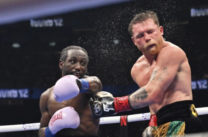 Terence Crawford (trái) tung đòn trúng mặt Canelo Alvarez trong trận thống nhất các đai hạng siêu trung trên sân Allegiant, Las Vegas, Mỹ ngày 13/9/2025. Ảnh: AP