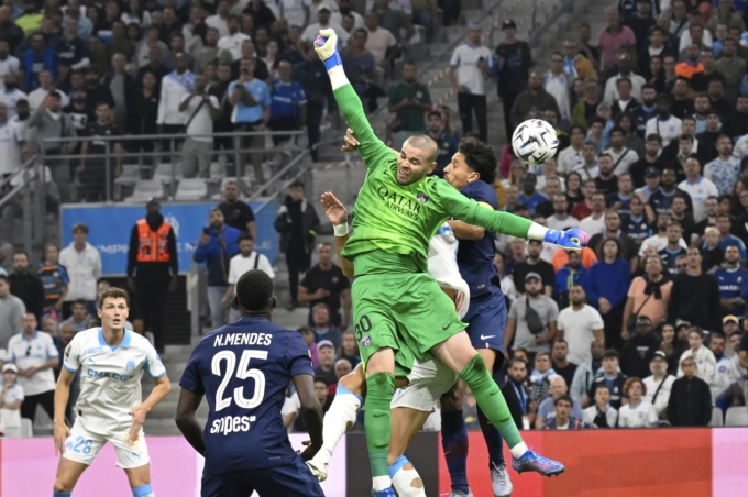 Lucas Chevalier (áo xanh) đấm bóng hụt để Nayef Aguerd ghi bàn, khiến PSG thua Marseille 0-1 ở vòng năm Ligue 1 trên sân Velodrome, Marseille, Pháp ngày 22/9/2025. Ảnh: AP