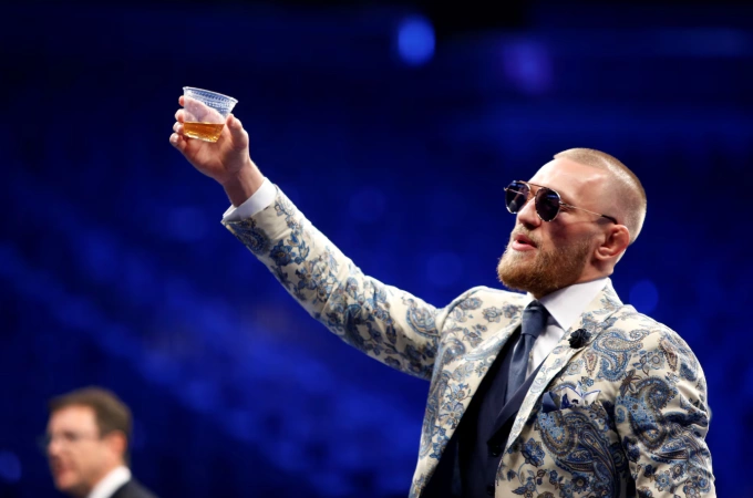 Conor McGregor nâng ly rượu whisky Ireland trong buổi họp báo sau trận đấu tại Nhà thi đấu T-Mobile ở Las Vegas, Nevada, Mỹ ngày 27/8/2017. Ảnh: Reuters