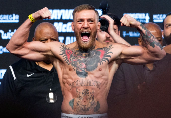 Nhà vô địch hạng nhẹ UFC Conor McGregor tạo dáng trên bàn cân trong buổi cân chính thức tại T-Mobile Arena ở Las Vegas, Nevada, ngày 25/8/2017. Ảnh: Reuters