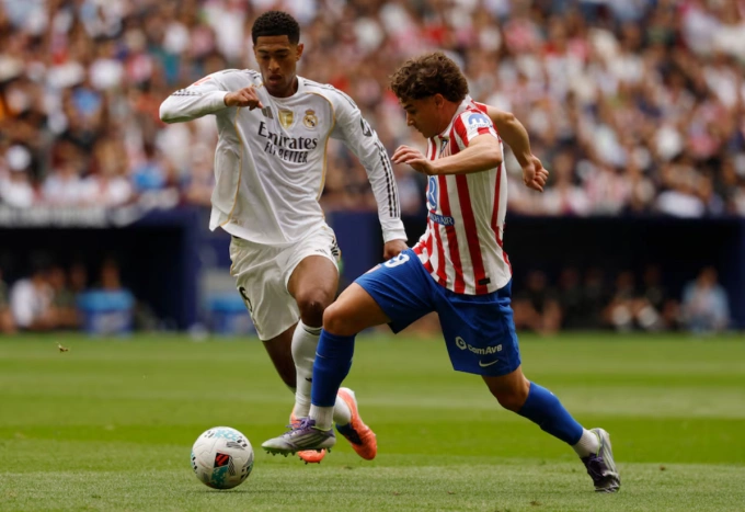 Jude Bellingham (trái) tranh chấp với Julian Alvarez. Ảnh: Reuters