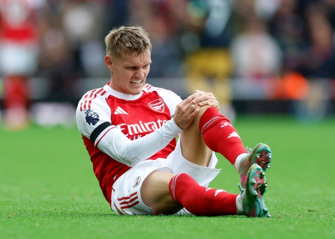 Martin Odegaard ôm đầu gối và rời sân từ hiệp một. Ảnh: Reuters