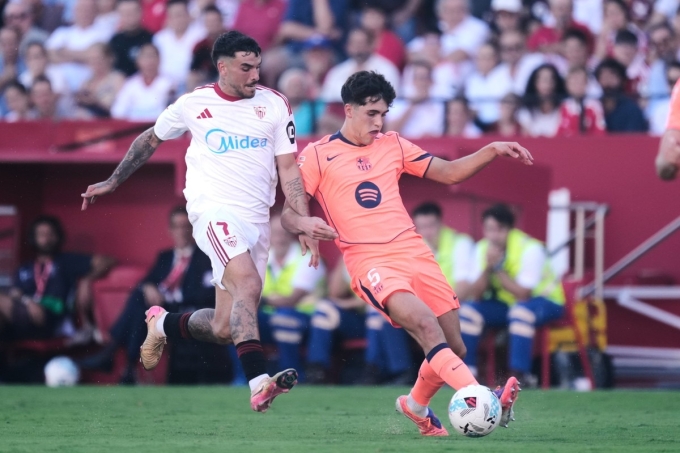 Tiền đạo Sevilla Isaac Romero gây sức ép với Pau Cubarsi trong trận thắng Barca 4-1 ở vòng 8 La Liga ngày 5/10. Ảnh: AP