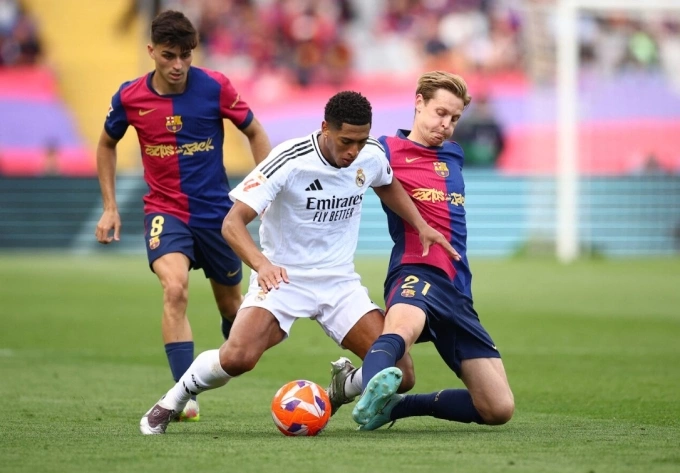 Frenkie de Jong (phải) tranh chấp với Jude Bellingham trong trận Barca thắng Real 4-3 trên sân Montjuic, Barcelona, Catalunya, Tây Ban Nha ngày 11/5/2025. Ảnh: Reuters