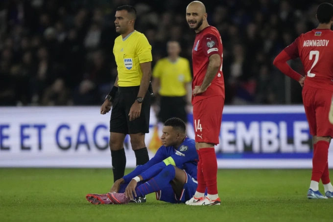 Kylian Mbappe ngồi bệt xuống sân vì chấn thương mắt cá. Ảnh: AP