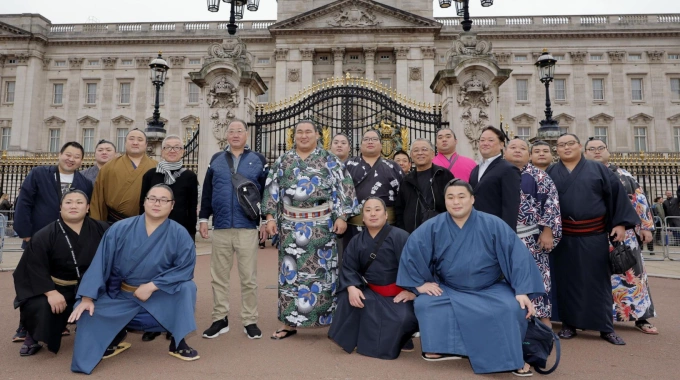 Các võ sĩ sumo Nhật Bản chụp ảnh lưu niệm trước Cung điện Buckingham. Ảnh: AP