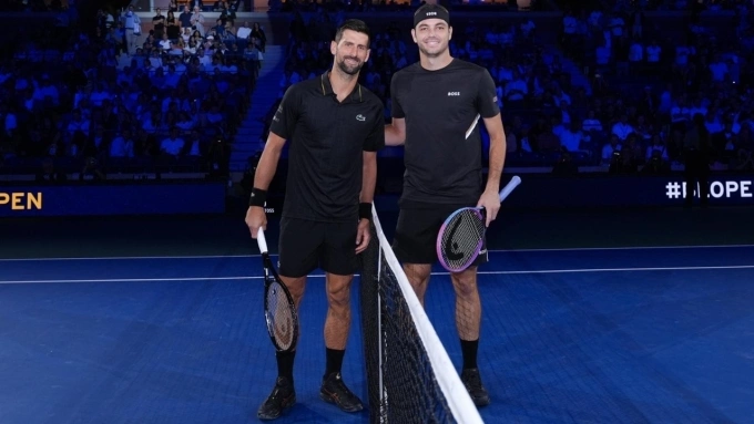 Djokovic (trái) và Fritz ở bán kết Mỹ Mở rộng, trên sân Arthur Ashe, New York hồi tháng trước. Ảnh: Reuters