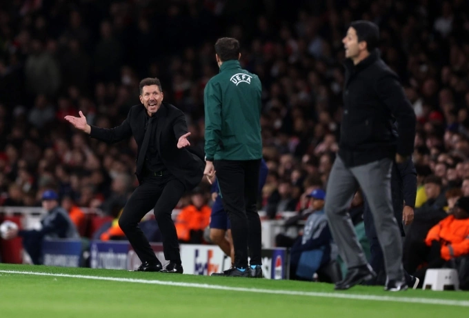 HLV Simeone (trái) phản ứng với trọng tài thứ tư, trên sân Emirates, London, Anh hôm 21/10. Ảnh: Reuters