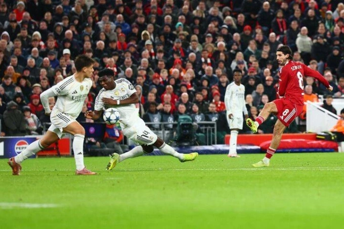 Szoboszlai (phải) dứt điểm khiến bóng bật tay Tchouameni trong trận Liverpool 1-0 Real ở lượt bốn vòng bảng Champions League tối 4/11. Ảnh: Rex