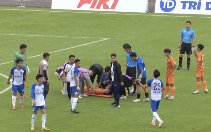 Nguyễn Anh Tuấn (áo cam giữa) được đưa lên cáng sau khi bị co giật trong trận Trẻ Phù Đổng thắng Hà Nội Bulls 2-1 ở lượt bốn bảng A giải hạng Ba Quốc gia 2025, trên sân Hoài Đức, Hà Nội ngày 5/11/2025. Ảnh: Chụp màn hình