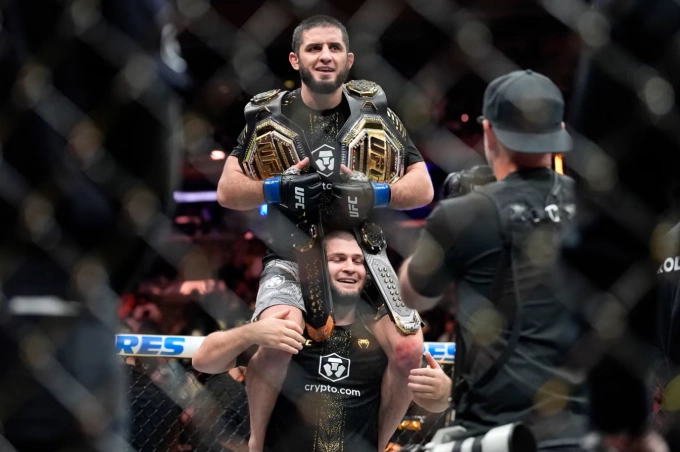 Khabib Nurmagomedov nâng Islam Makhachev mừng hai đai vô địch UFC. Ảnh: AP