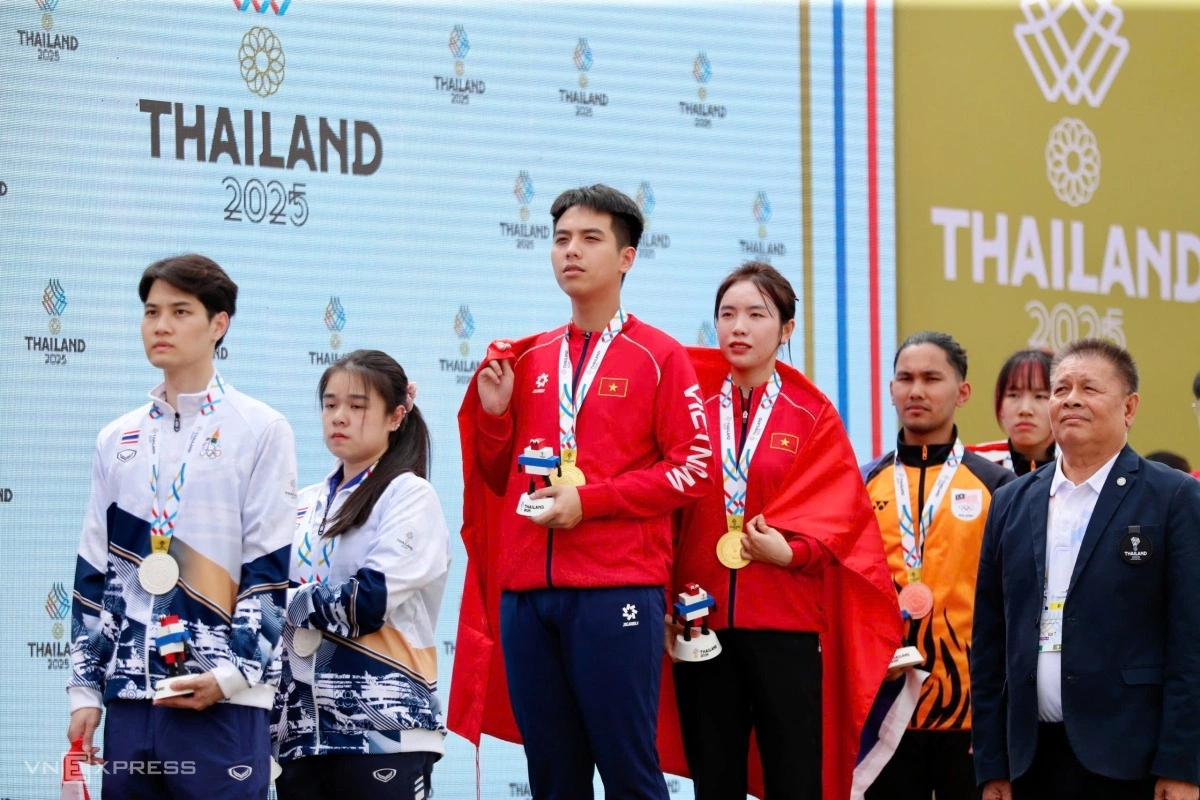 Tâm Quang - Mộng Tuyền chào cờ trong nghi thức cử quốc ca của lễ trao huy chương môn bắn súng. Ảnh: Hiếu Lương