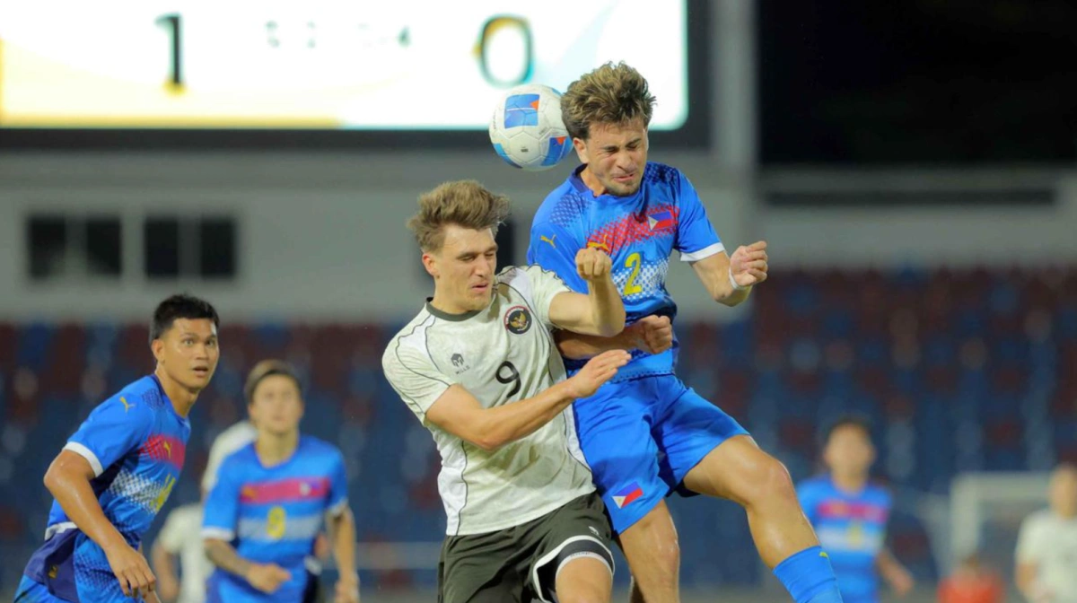 Tiền đạo Indonesia Mauro Nils Zijlstra (trái) tranh chấp bóng bổng với Noah River Leddel của Philippines trong trận mở màn bảng C SEA Games 2025 trên sân 700th Anniversary, Chiang Mai, Thái Lan, ngày 8/12. Ảnh: Bola