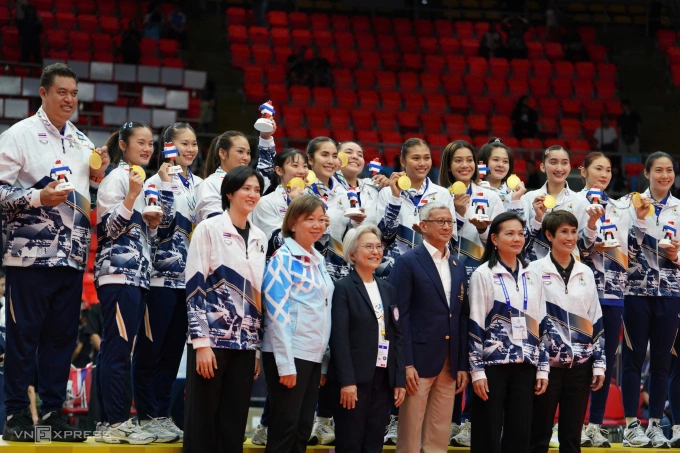 HLV Kiattipong (trái) cùng các cầu thủ khoe HC vàng sau trận chung kết bóng chuyền nữ SEA Games 33 tại nhà thi đấu Huamark, thành phố Bangkok, Thái Lan tối 15/12/2025. Ảnh: DailyNews