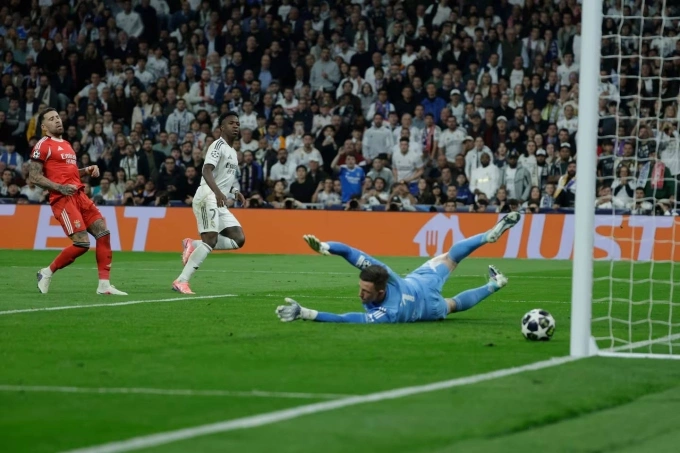 Vinicius (áo trắng) ấn định chiến thắng trận Real 2-1 Benfica ở lượt về vòng play-off Champions League tối 25/2. Vinicius ghi bàn cho Real