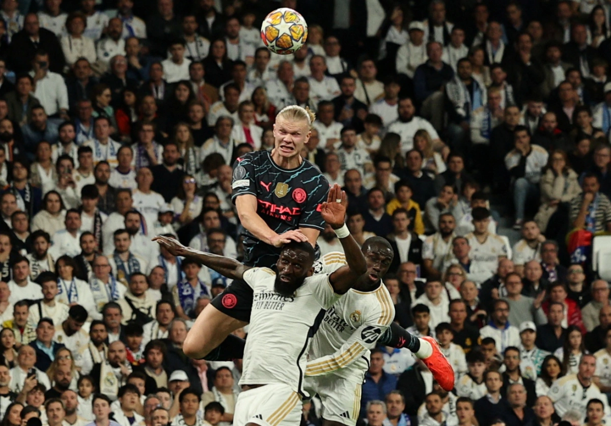 Erling Haaland bật nhảy tranh chấp bóng với Antonio Rudiger và Ferland Mendy trong trận Man City gặp Real Madrid trên sân Bernabeu, Madrid, Tây Ban Nha ngày 9/4/2024. Erling Haaland tranh chấp bóng với các cầu thủ Real Madrid