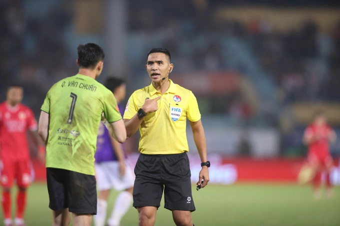 Trọng tài người Malaysia Nazmi Bin Nasaruddin (áo vàng) nhắc nhở thủ môn Quan Văn Chuẩn của Hà Nội FC. Ảnh: VPF Trọng tài nhắc nhở thủ môn Quan Văn Chuẩn