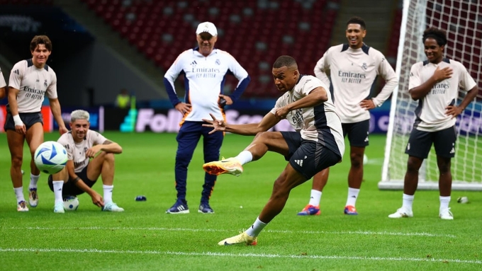 Ancelotti (áo trắng) dõi theo một cú dứt điểm của Mbappe trong buổi tập cùng Real Madrid năm 2025. Ancelotti quan sát Mbappe tập luyện