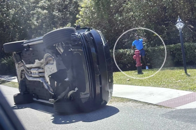 Woods đứng cạnh chiếc xe bị lật của mình ở Florida hôm 27/3. Ảnh: AP